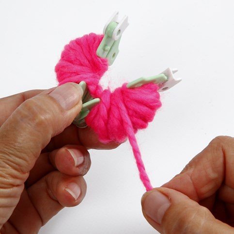 A Hat with two Pom Poms knitted on a Knitting Loom