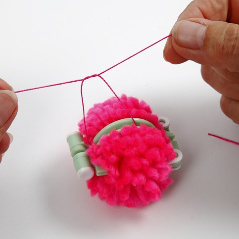 A Hat with two Pom Poms knitted on a Knitting Loom