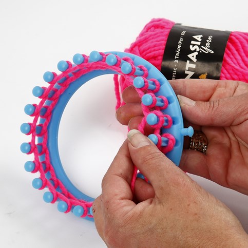 A Hat with two Pom Poms knitted on a Knitting Loom