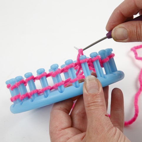 A Hat with two Pom Poms knitted on a Knitting Loom