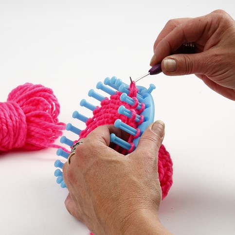 A Hat with two Pom Poms knitted on a Knitting Loom