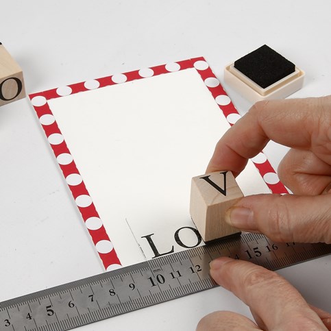 A Valentine Card with a sewn-on Paper Heart and stamped Text