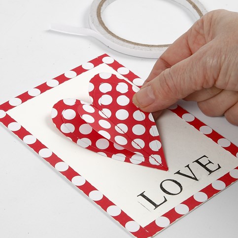 A Valentine Card with a sewn-on Paper Heart and stamped Text