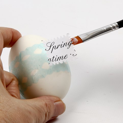 A Natural Egg with Printed Text and a decorative Tissue Paper Waistband