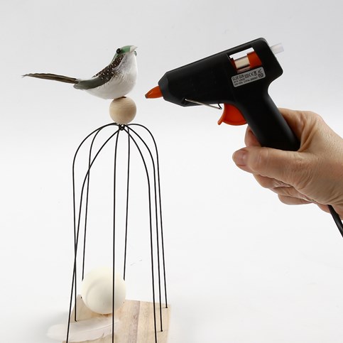 A Bird on a Bird Cage made from Stub Wires on a Wooden Icon Plate