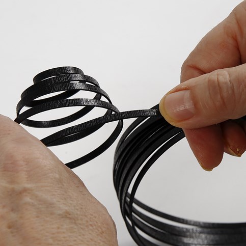 A coil-shaped Egg made from black, flat Aluminium Wire