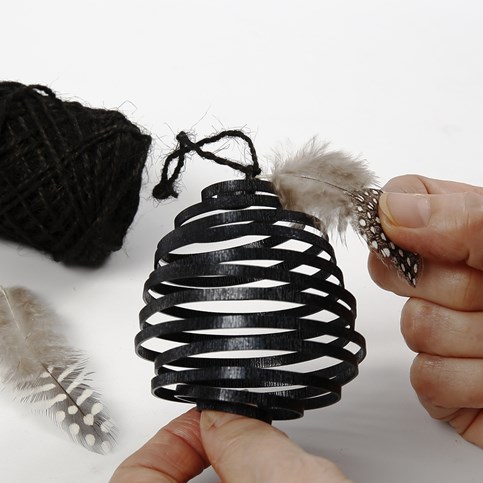 A coil-shaped Egg made from black, flat Aluminium Wire