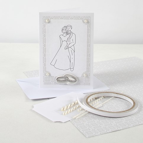 An Invitation and Table Decorations for a White Wedding